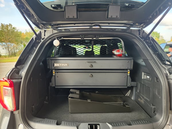 Opened trunk of police vehicle with drawers inside