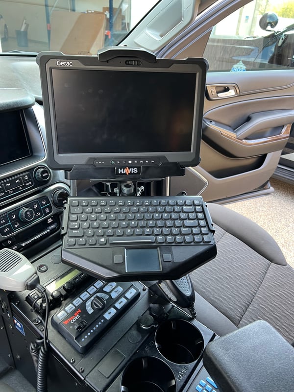 laptop in console area of police vehicle interior