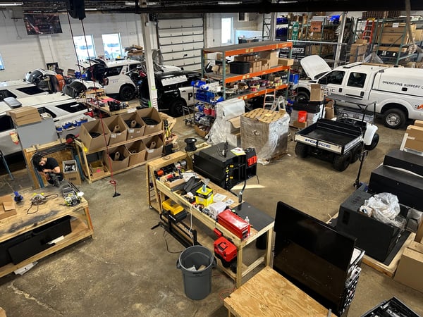 shop interior with many work stations and police vehicles