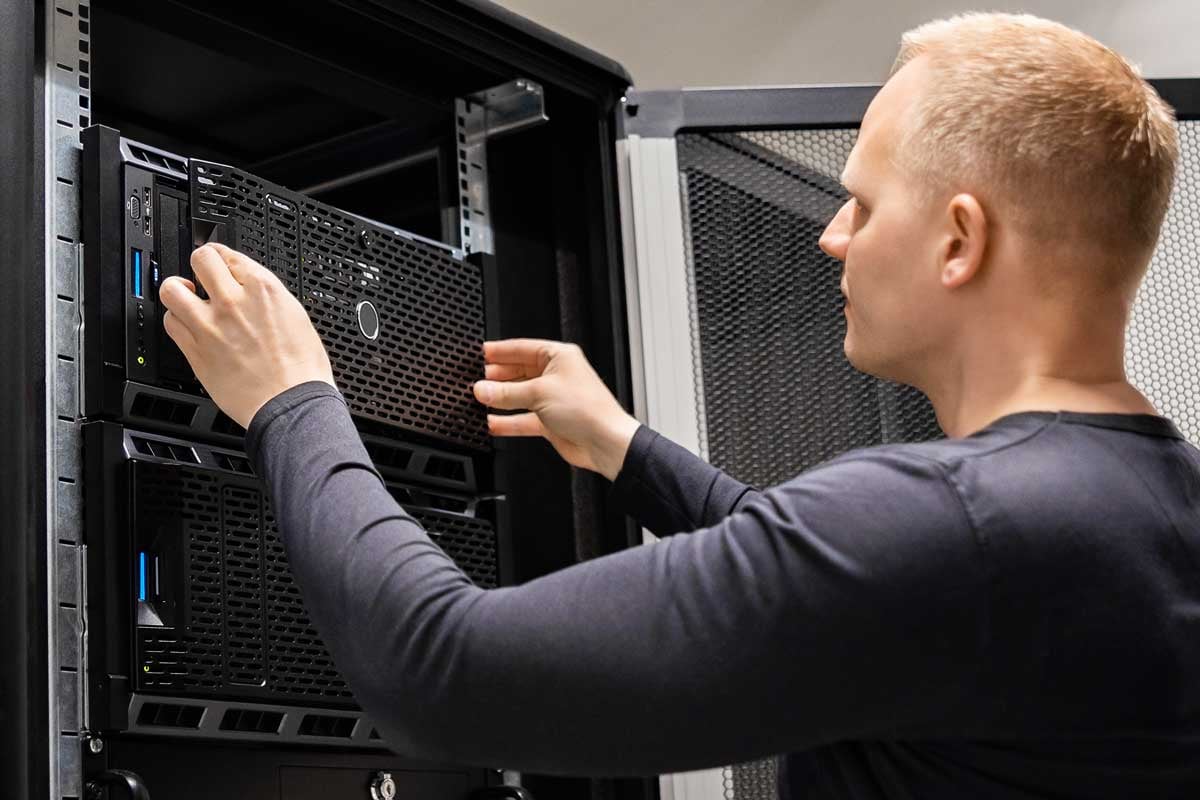 man changing face plate on server rack